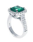 A cushion cut emerald ring in white gold, top and lateral profile visibles.
