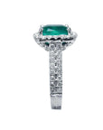 Cushion cut Colombian emerald ring with alo diamond and side accent diamonds on the band, side profile view.