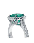 Cushion cut 3.92 ct. natural emerald ring in 14K white gold with diamond halo and pavé band.