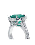 Cushion cut 3.92 ct. natural emerald ring in 14K white gold with diamond halo and pavé band.