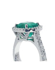 Cushion cut 3.92 ct. natural emerald ring in 14K white gold with diamond halo and pavé band.
