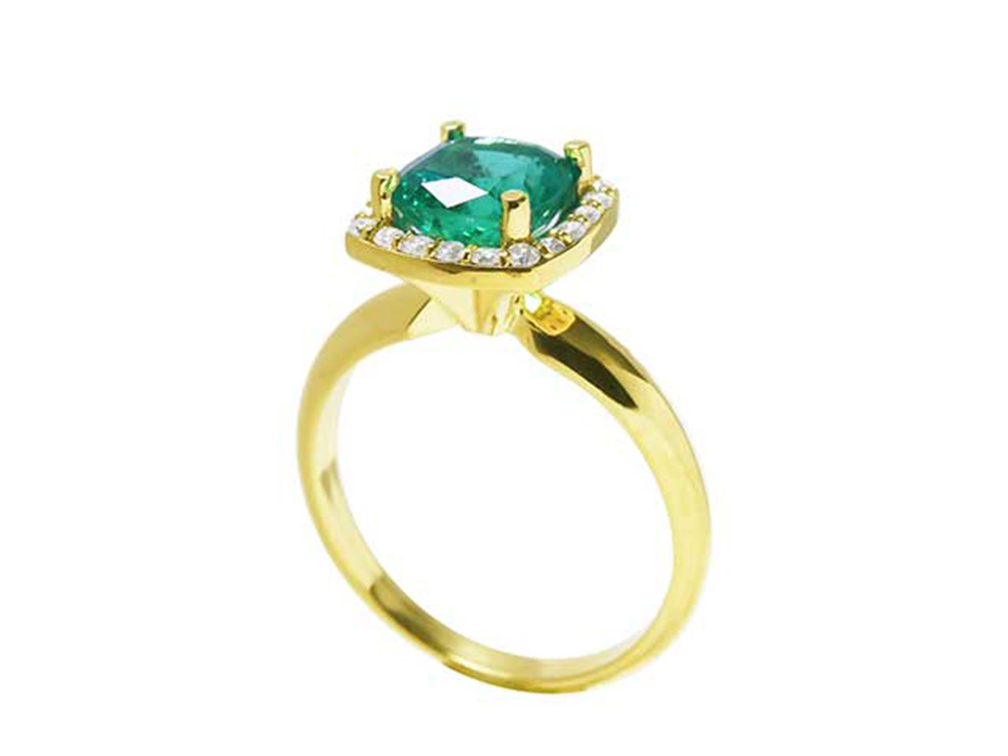This 14k yellow gold cushion cut emerald ring is showing its lateral profile from the top to the band.