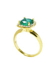 This 14k yellow gold cushion cut emerald ring is showing its lateral profile from the top to the band.