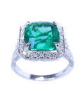 A cushion cut emerald white gold ring for women displaying a halo diamond and side profile.