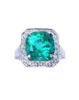 Cushion cut 3.68 ct Colombian emerald engagement ring with diamond halo in 18K white gold.