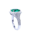 Cushion cut 3.68 ct emerald engagement ring with diamond halo and pavé band in 18K white gold.