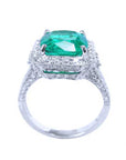 The lateral view of a cushion cut emerald and diamond ring for women.
