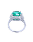Cushion cut 3.68 ct Colombian emerald engagement ring with diamond halo in 18K white gold.