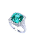 Cushion cut 3.68 ct Colombian emerald ring with diamond halo and pavé band in 18K white gold.