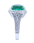 A cushion cut emerald and accent diamond engagement ring displaying the top and side profile.