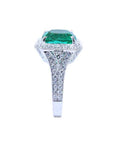 A cushion cut emerald and accent diamond engagement ring displaying the top and side profile.