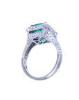 Cushion cut emerald engagement ring with diamond halo in 18K white gold.