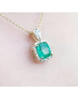 1.99 ct cushion-cut emerald halo pendant with natural diamonds on a 14K yellow gold chain.