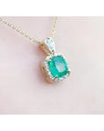1.99 ct cushion-cut emerald halo pendant with natural diamonds on a 14K yellow gold chain.
