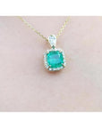 1.99 ct. cushion-cut emerald halo pendant with natural diamonds on a 14K yellow gold chain.