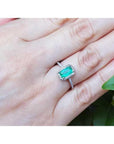 14K white gold cushion-cut emerald solitaire ring with rope detailing on a hand.