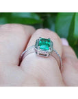 14K white gold cushion-cut emerald solitaire ring with distinctive rope detailing on a hand.