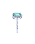 14K white gold cushion-cut emerald ring with diamond halo and rope detailing.
