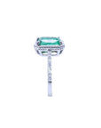 14K white gold cushion-cut emerald ring with diamond halo and rope detailing.