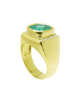 Men's 18k yellow gold ring with a cushion-cut emerald and channel-set diamonds.