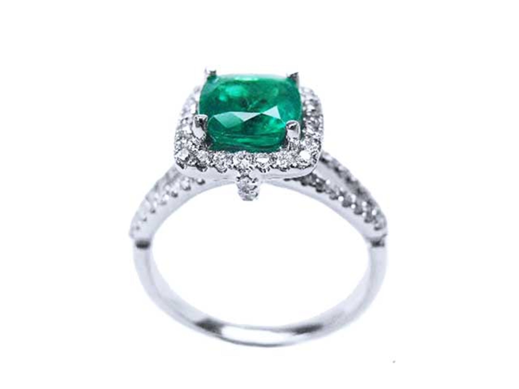 A 18k white gold emerald ring cushion cut and diamonds on a white background.