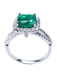 A 18k white gold emerald ring cushion cut and diamonds on a white background.