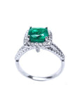 A 18k white gold emerald ring cushion cut and diamonds on a white background.
