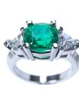 Emerald cushion cut trillion accent diamonds ring for women on a white background.