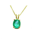 A yellow gold natural emerald cushion cut pendant on a topside view position.