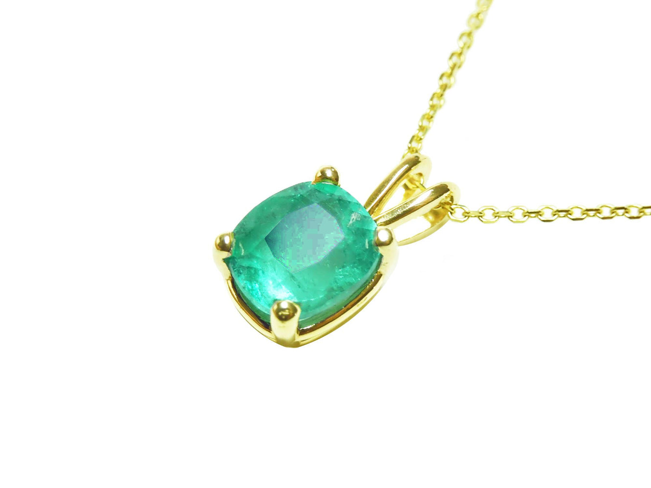 This solitaire emerald cushion cut pendant displays its left side profile, top and gallery perspectives visibles.