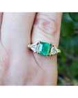 1.47 ct emerald-cut Colombian emerald ring with trillion diamonds in 18k yellow gold.