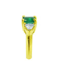 1.47 ct emerald-cut emerald and trillion diamonds ring in 18k yellow gold.