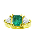 Square emerald-cut natural colombian emerald ring and side trillion diamonds in 18k yellow gold.