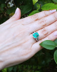 Anillo con esmeralda para bodas elaborado en oro blanco de 18k, exhibido en una mano de mujer