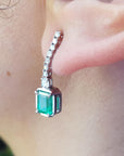 Close-up of a Mother’s Day emerald earring on an ear with a blurred background