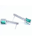 18K white gold dangling emerald-cut emerald earrings with diamond-studded straight lines.