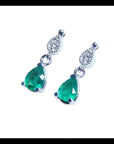 Dangling teardrop emerald earrings with diamond-studded pear links in 14K white gold.