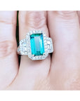 Anillo con esmeralda colombiana rectangular certificada por GIA rodeada de diamantes en oro blanco.