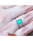 Anillo de compromiso de oro blanco 18k con esmeralda colombiana y diamantes trapezoide.