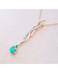 14K yellow gold twisted slider necklace with a pear-shaped emerald and diamond accents.