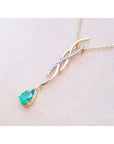 14K yellow gold twisted slider necklace with a pear-shaped emerald and diamond accents.