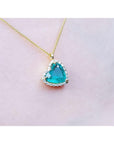 THeart shaped emerald halo necklace on a pink skin background