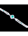 18K white gold bracelet with a central emerald, accented by pearls and small green emeralds.