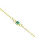 The distant view of a gold bracelet with a genuine emerald on a distant view.