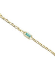 Gold bracelet with a central emerald stone and natural diamond accent on a white background.