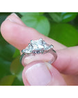 14K white gold ring with a princess cut center diamond and two trillion side diamonds.