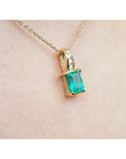 14K yellow gold pendant with an emerald-cut green emerald and diamond accents on a delicate chain.