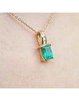 14K yellow gold pendant with an emerald-cut green emerald and diamond accents on a delicate chain.