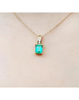 14K yellow gold pendant with a rectangular Colombian emerald and diamond accents on a delicate chain.