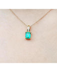 14K yellow gold pendant with a rectangular Colombian emerald and diamond accents on a delicate chain.